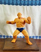 Front view of The Thing statue on base