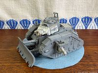 Front three-quarter view of unpainted Leman Russ tank on felt base