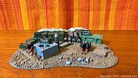 Overall view of painted Ammo Dump terrain showing crates, shells, sandbags