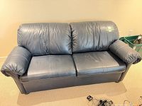 Front view of navy leather sofa showing overall form and upholstery