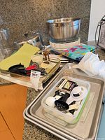 overview of lot with mixing bowl, baking sheets, measuring tools, funnels and mitts