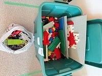 Top view of tote filled with bricks and separate bag of cars