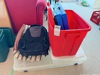 Overall lot showing red tote, backpack, striped bag, blue inserts, under-bed bin