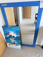 Mirror with blue frame and poster leaning against it