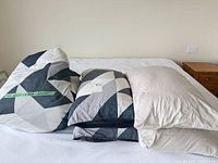 Stacked duvet cover, pillows and pillowcases on bed