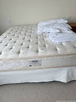 Full view of Simmons king pillow-top mattress with protector and pillows