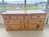 Front view of pine dresser showing all seven drawers and knob hardware