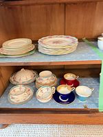 Stacked salad plates and floral dinner plates on upper shelf