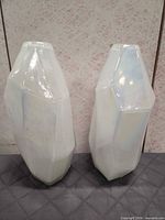Front view of two iridescent faceted vases