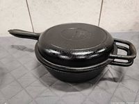 Deep skillet and lid stacked showing exterior finish and handles