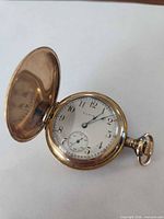 Closed view of Elgin hunter pocket watch opened to show dial and cover