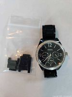 Front view of Fossil watch with spare links in bag