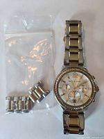 Front view of Michael Kors Ritz chronograph watch with bracelet and spare links in bag