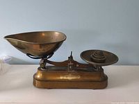 Full view of brass balance scale with both pans attached
