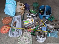 overview of entire lot on floor: hand tools, plaques, bird feeders, tote with connectors
