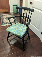 Front view of black Windsor-style armchair with patterned cushion