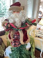 Plush Santa tree topper on greenery