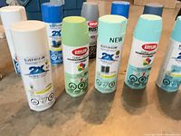 Front row of assorted Rust-Oleum and Krylon cans showing colors light blue, teal, light green, white