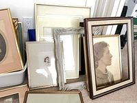 Group of assorted frames leaning against wall