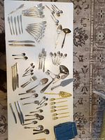 Overview of entire flatware lot laid out on table