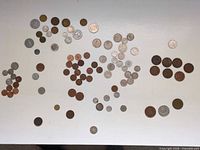Overview of all coins spread out showing mix of silver-tone and copper/bronze pieces