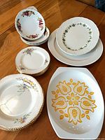 Mixed dinnerware laid out showing variety of plates and bowls