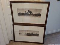 Two framed etchings leaning against door