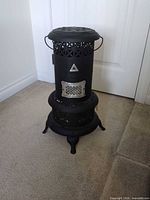 Full view of black Perfection kerosene heater on carpet