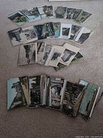 Three rows of assorted vintage postcards spread on carpet
