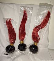 Three sealed wigs showing red hair and black bases