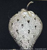 Front close-up of silver strawberry brooch
