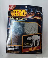 Front of sealed Metal Earth Star Wars AT-AT kit showing branding and steel sheets within package