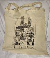Front view of natural canvas tote bag showing York illustration and handles