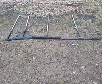 Full view of five long-handled tools laid on ground