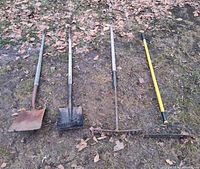 Four garden hand tools laid out: two shovels, wood-handle rake, fiberglass-handle rake