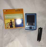 PalmOne Zire 31 PDA, software CD, three stylus pens displayed together
