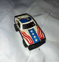Top angled view of die-cast car showing flag graphics and overall condition