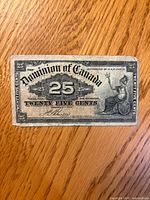 Obverse of Dominion of Canada 25¢ bill showing design details and wear