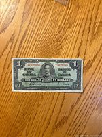 Obverse showing King George VI portrait, serial number 7629156, denomination and bilingual text