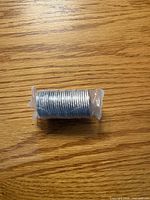 Entire sealed roll of coins on wooden surface