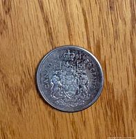 Reverse of 1961 Canadian 50-cent coin showing coat of arms and date