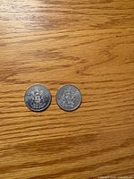 Both coins reverse side showing Canadian Coat of Arms
