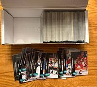 Open storage box showing rows of sleeved hockey cards and portion of cards spread out to display fronts
