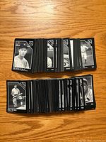 Two orderly stacks of Conlon Collection black-and-white baseball cards on wood surface