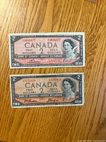 Obverse of both $2 notes showing Queen Elizabeth II, serial numbers, bilingual text