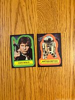 Fronts of two 1977 Star Wars stickers showing characters Han Solo and R2-D2