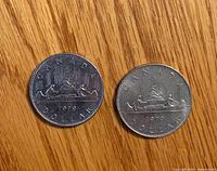 Reverse side showing Voyageur canoe design on both coins