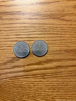 Reverse side of both 1983 Canadian Voyageur dollars showing canoe scene