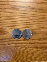 Front view showing Voyageur canoe design and 1985 date on both coins