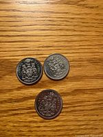 Three 1968 Canadian 50-cent coins reverse side